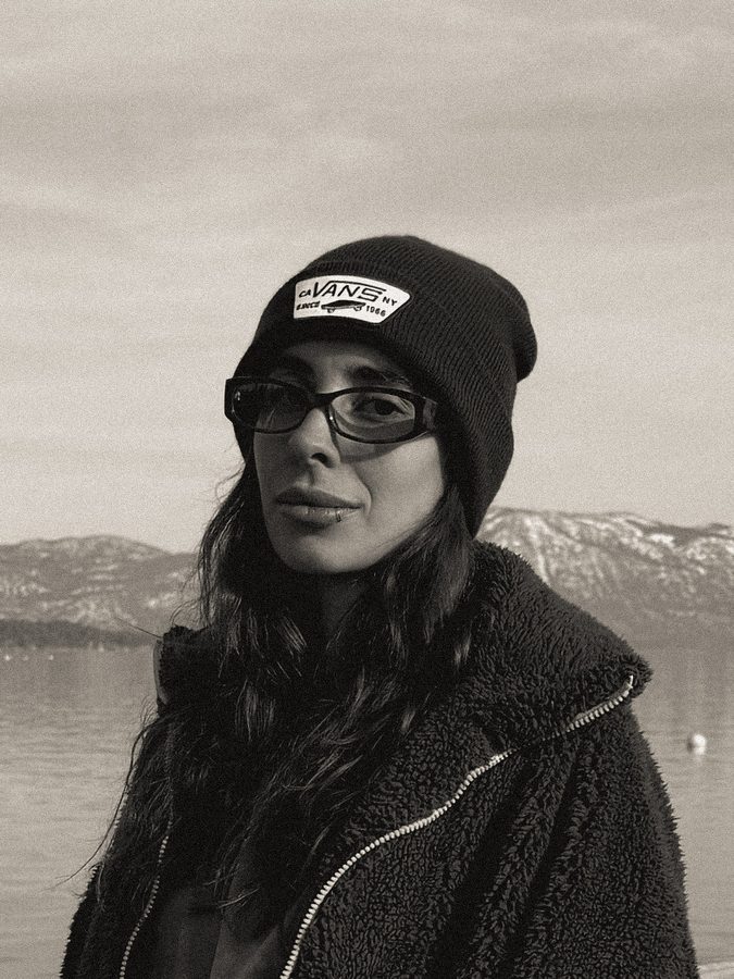 Black and white portrait in a beanie by a lake